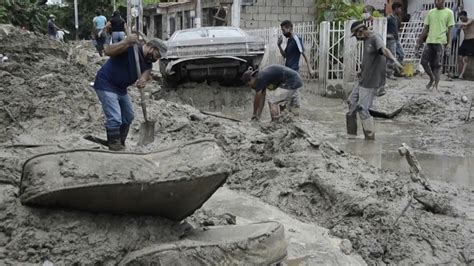 cleaning mud Venezuela|Venezuelans clean muddy streets after El Limon River .